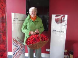 Bestwood Village WI President Brenda Langsdale delivers a basket of crocheted poppies to BBC Radio Nottingham.