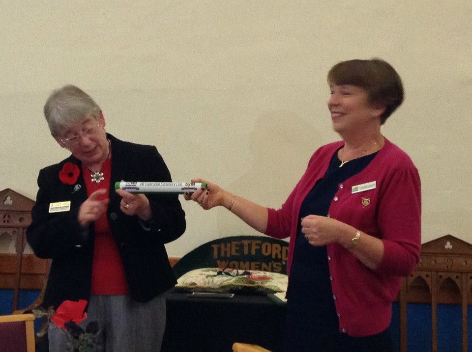 Norfolk Federation Chairman Wendy Adams passes the baton to Suffolk West Federation Chairman Elizabeth Lansman.
