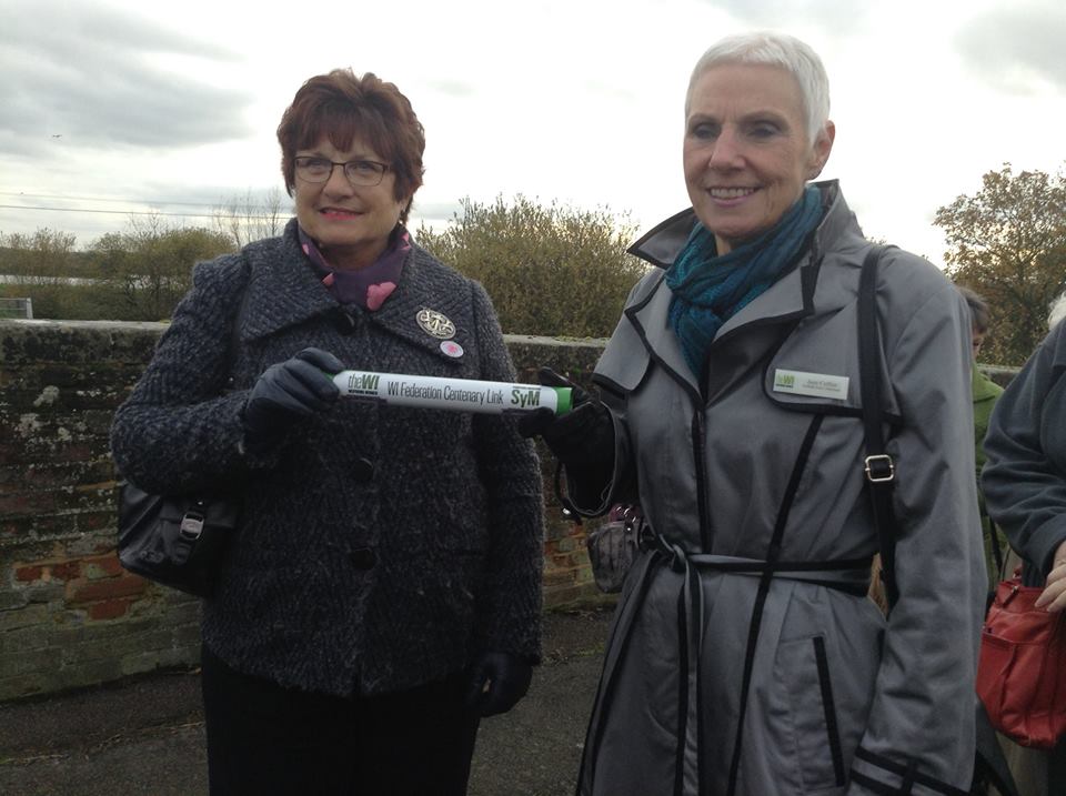 Pat Pratley, Essex Federation Chairman, receives the Baton from Jane Collier, Chairman of the East Suffolk Federation, at Cattawade Bridge.